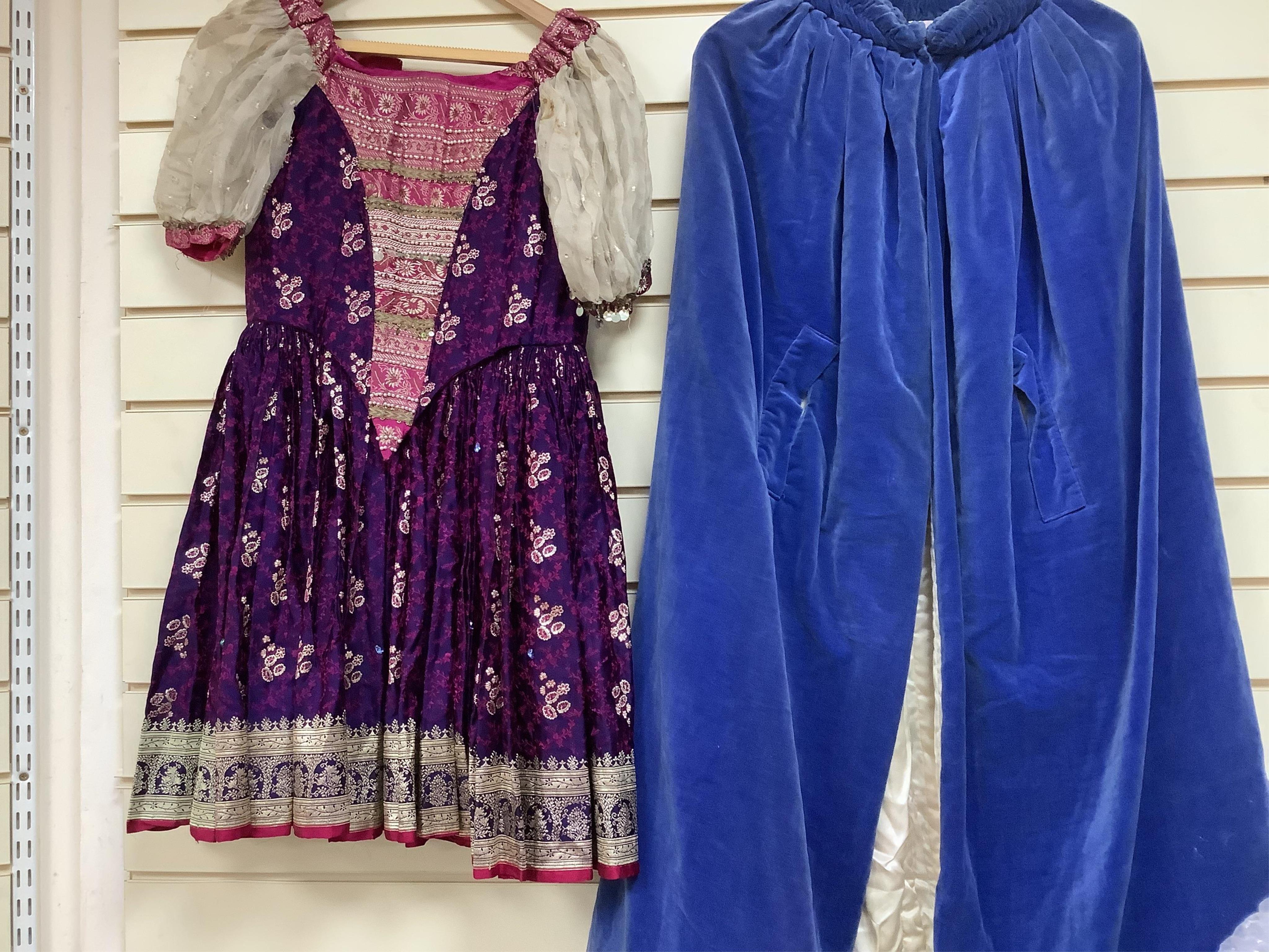 A child’s theatrical brocade dress and a lady’s blue velvet, cream and silk-lined cape, labelled Jenners, Edinburgh- 116cm long.